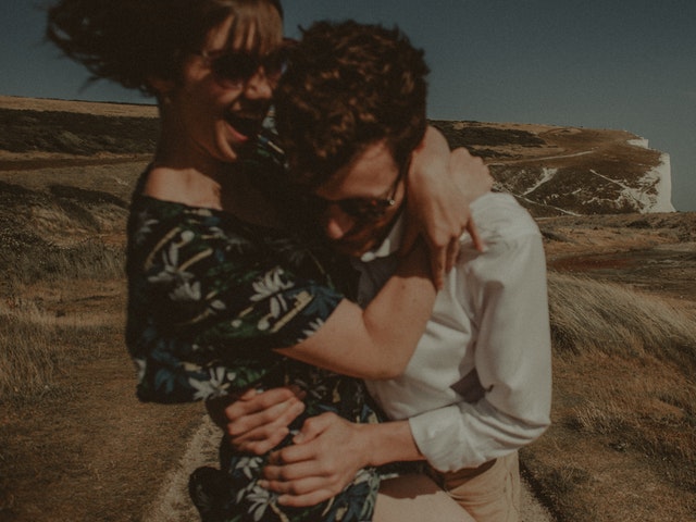 A man and woman hugging in front of the white cliffs.