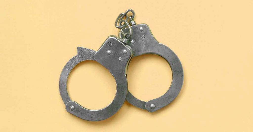Handcuffs on a yellow background.